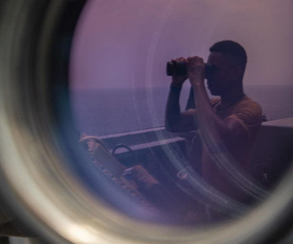Soldado a bordo de un portaaviones estadounidense observa el océano. Imagen Departamento de Defensa de los EE. UU. de dominio público.