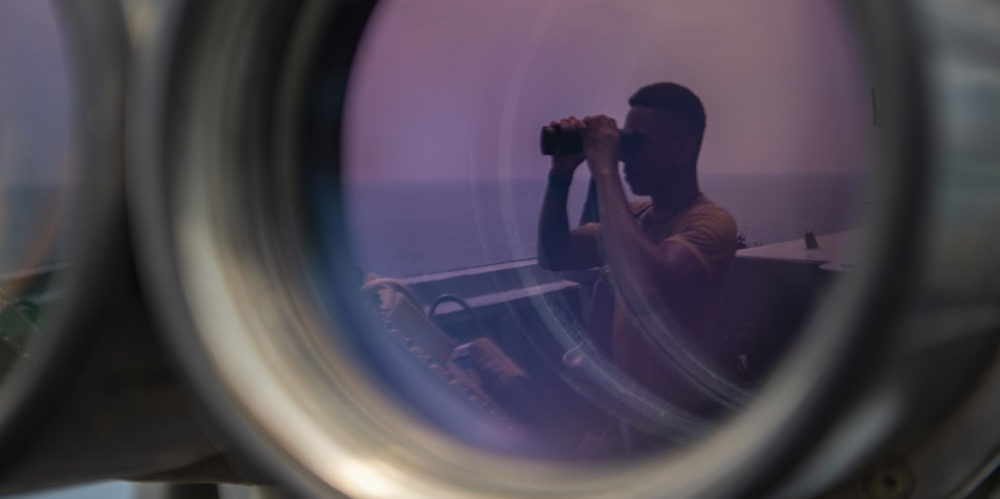 Soldado a bordo de un portaaviones estadounidense observa el océano. Imagen Departamento de Defensa de los EE. UU. de dominio público.