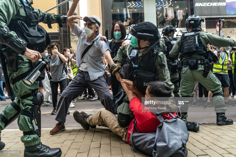 En la disputa entre manifestantes y policia, el Pastor Roy Chan, protege a un niño de los golpes de la policia. (Foto: @Jewpiter)